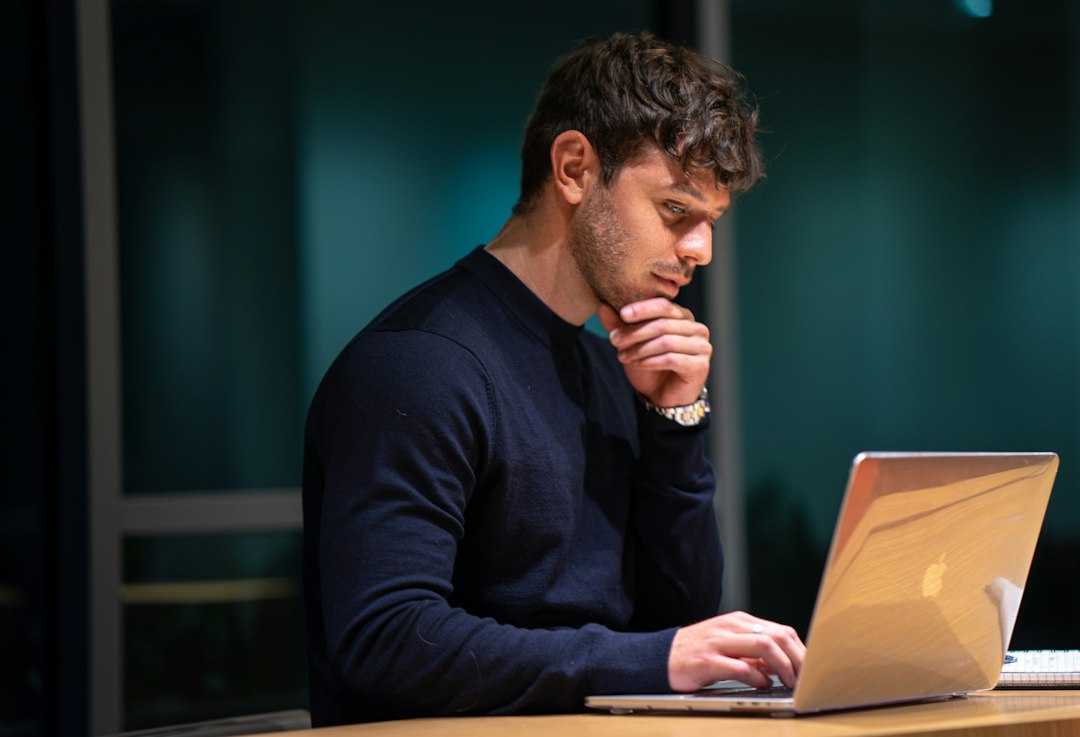Person reviewing information on a laptop while checking sources